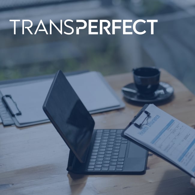 Laptop and health documents on a clipboard on a table.